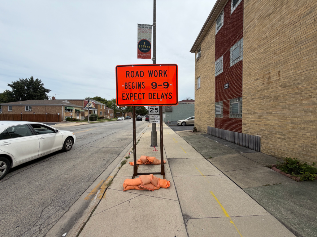 Orange traffic control sign along 16th Street in Berwyn stating that road work begins September 9 and drivers should expect delays.
