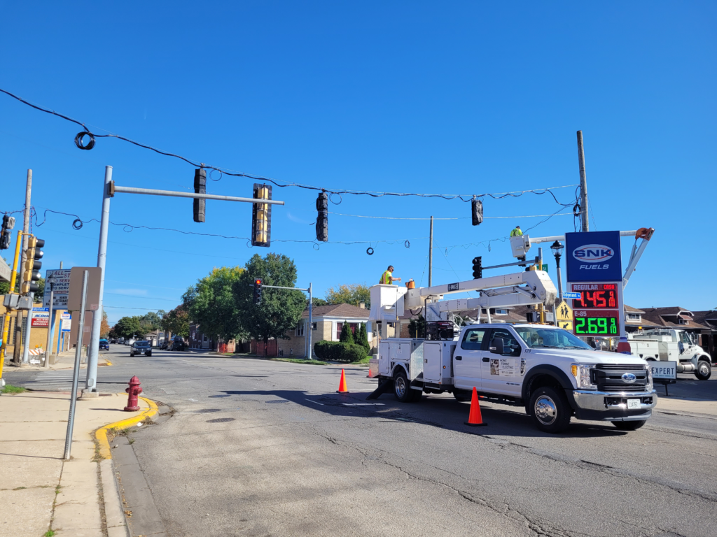 Crew using a bucket truck to install temporary traffic signals at a 16th Street intersection.