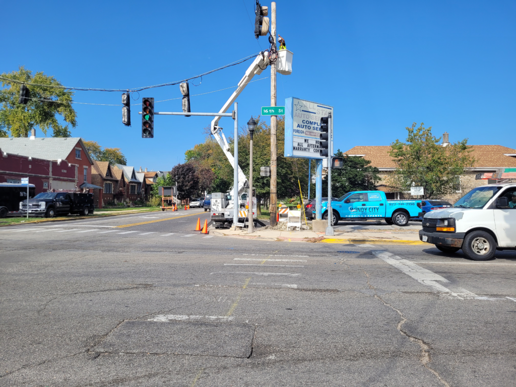 Crew using a bucket truck to install temporary traffic signals at a 16th Street intersection.